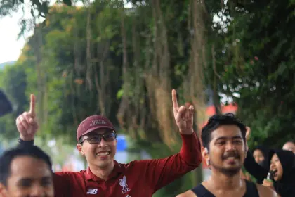 Dengan menggunakan jersey Liverpool, dr. Tirta disambut pelari dan masyarakat sekitar saat mengikuti Purwokerto Half Marathon 2026 pada Minggu (17/5/2026). (Sumber: Instagram @dr.tirta)