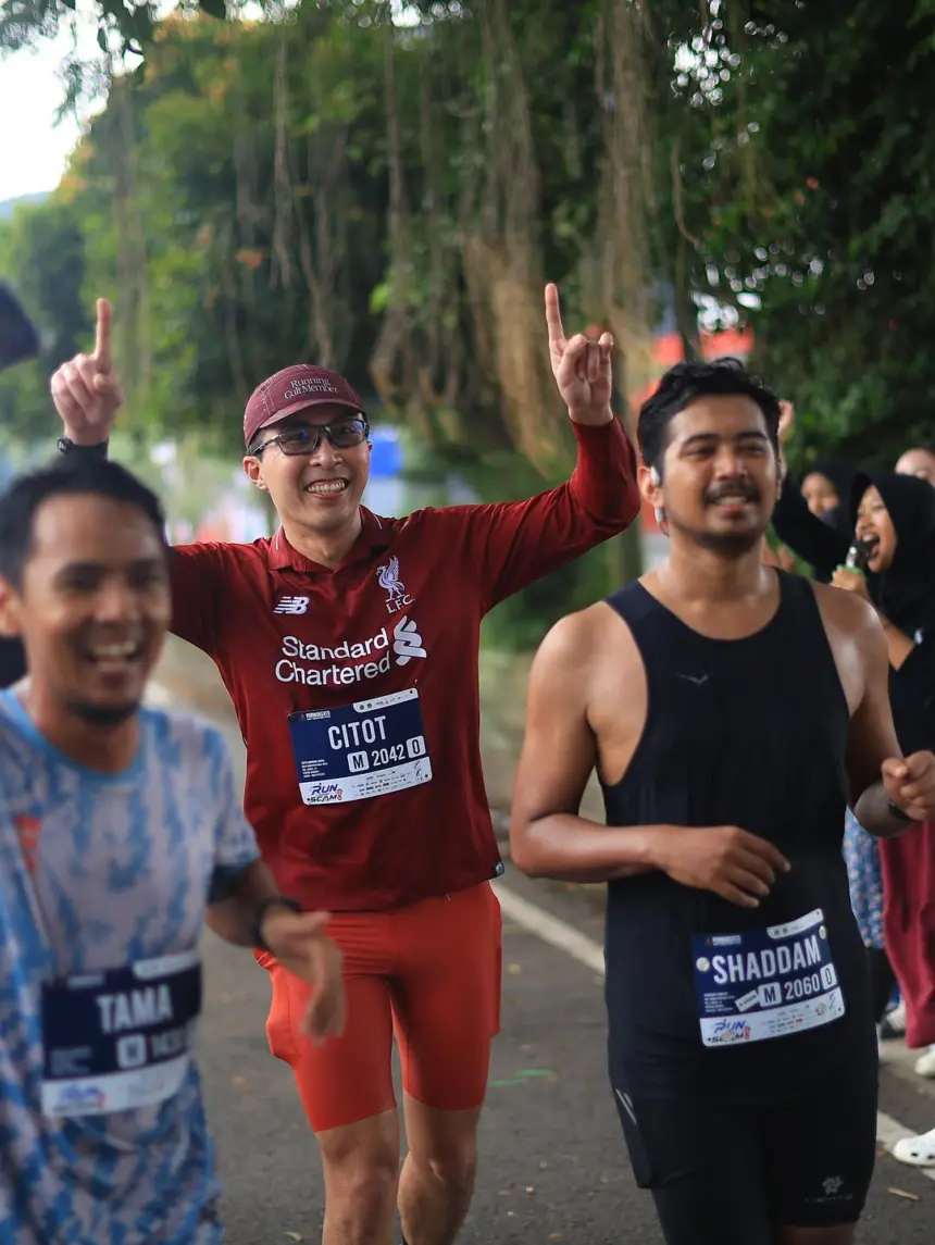 Dengan menggunakan jersey Liverpool, dr. Tirta disambut pelari dan masyarakat sekitar saat mengikuti Purwokerto Half Marathon 2026 pada Minggu (17/5/2026). (Sumber: Instagram @dr.tirta)